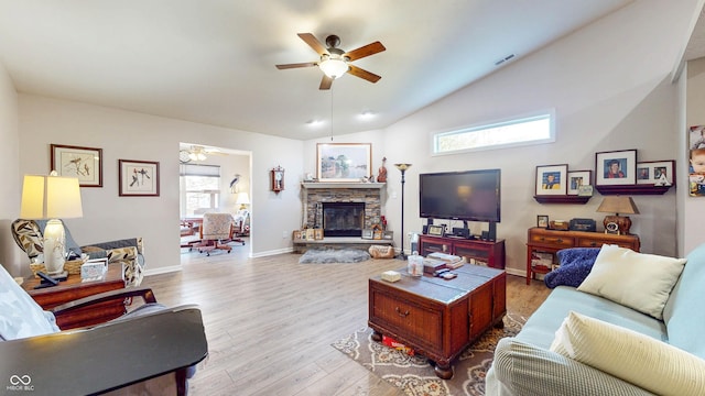 living room with visible vents, wood finished floors, a fireplace, ceiling fan, and vaulted ceiling