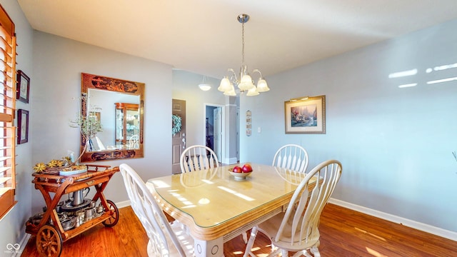 dining area with an inviting chandelier, baseboards, and wood finished floors