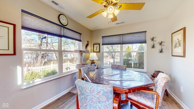 dining area featuring visible vents, baseboards, and wood finished floors