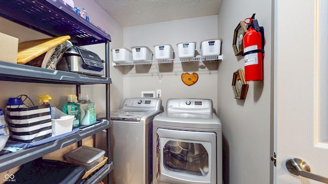 laundry room with washer and dryer, a textured ceiling, and laundry area