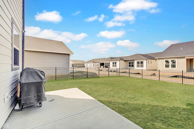 view of yard with fence, a patio area, and a residential view