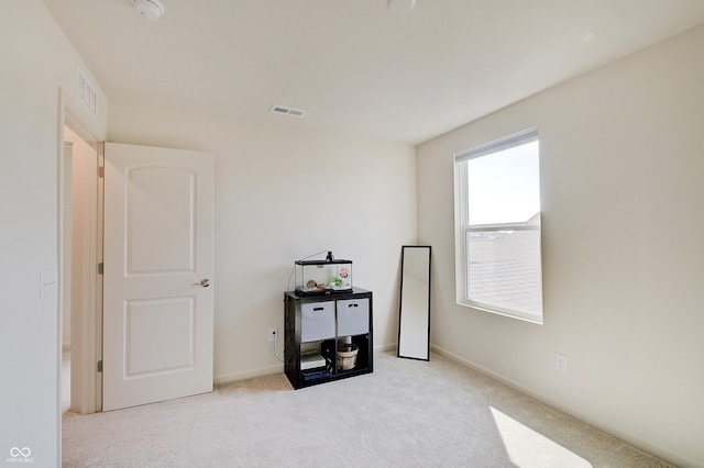 spare room with visible vents and light carpet