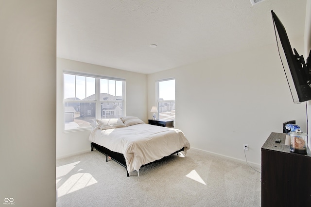 bedroom featuring baseboards and light colored carpet