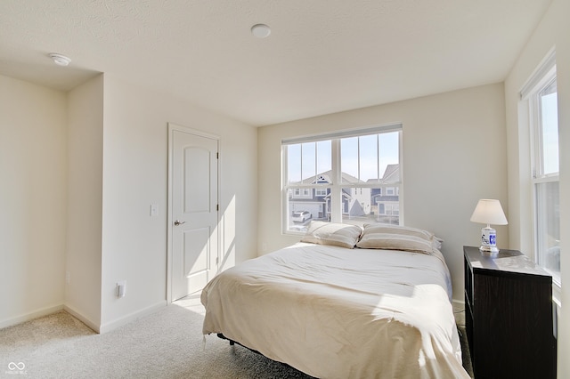 carpeted bedroom featuring baseboards and a textured ceiling