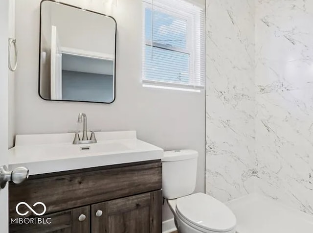 bathroom featuring vanity, toilet, and a stall shower