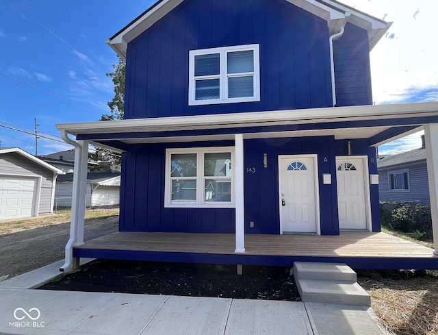 view of front of home with a porch, board and batten siding, and an outdoor structure