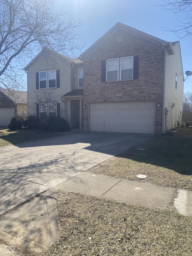 traditional home with brick siding, an attached garage, and driveway