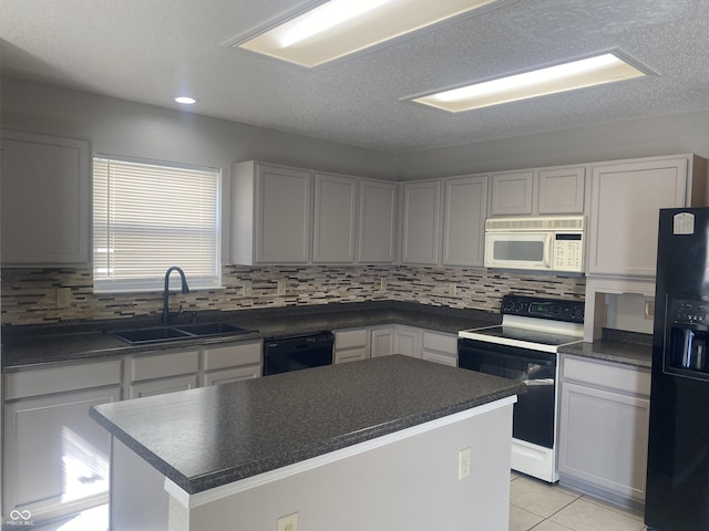 kitchen with black appliances, a sink, dark countertops, a center island, and light tile patterned floors