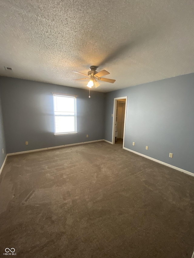 carpeted empty room with a textured ceiling, baseboards, and ceiling fan