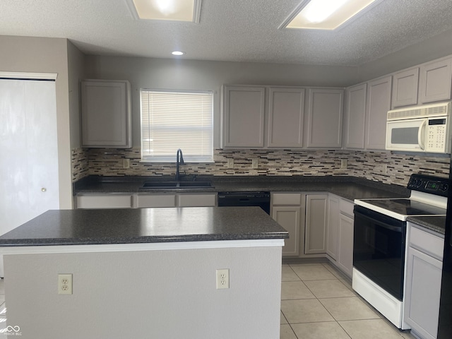 kitchen with white microwave, a sink, range with electric stovetop, dishwasher, and dark countertops