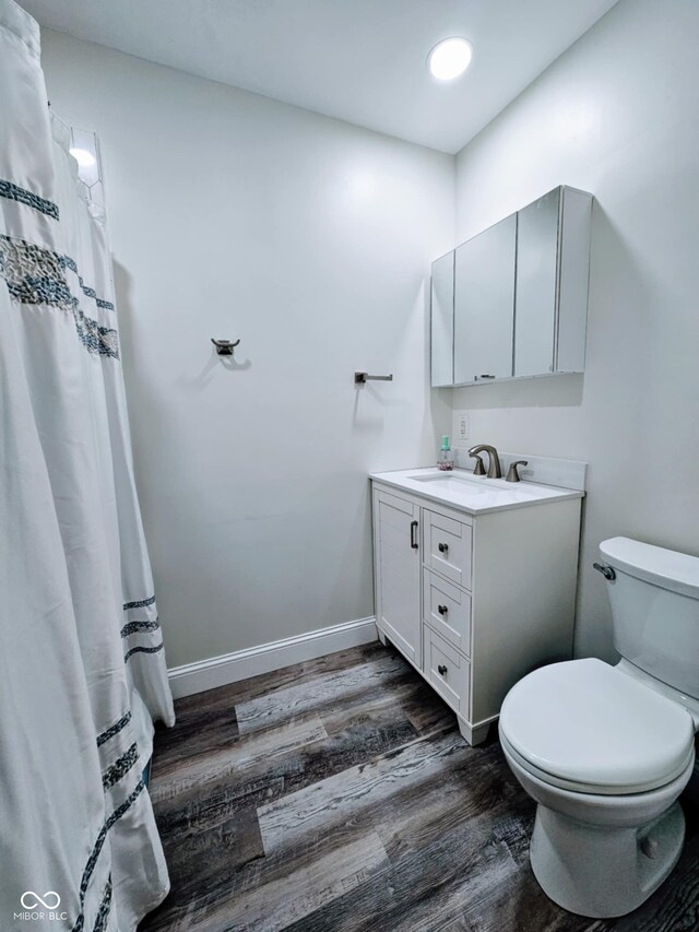 4109 E Epler Ave, Indianapolis, IN 46237 - bathroom with vanity, wood finished floors, baseboards, curtained shower, and toilet