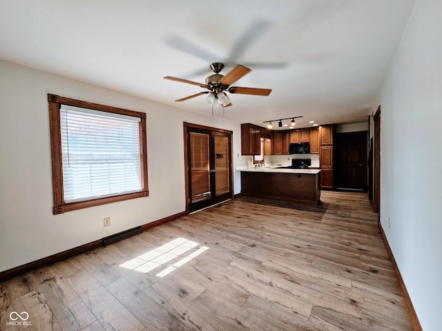 4109 E Epler Ave, Indianapolis, IN 46237 - kitchen featuring baseboards, a peninsula, light countertops, black microwave, and light wood-type flooring