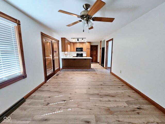 4109 E Epler Ave, Indianapolis, IN 46237 - kitchen with light wood-style flooring, a peninsula, black microwave, light countertops, and baseboards