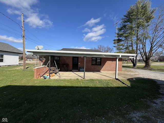 back of house with brick siding, a patio area, and a yard