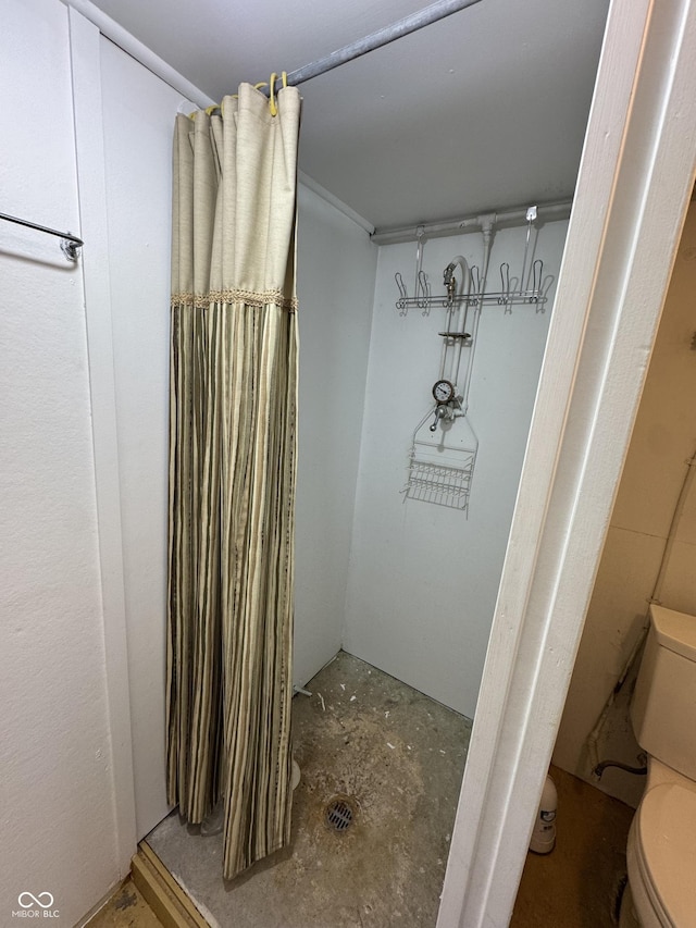 bathroom with toilet and concrete flooring