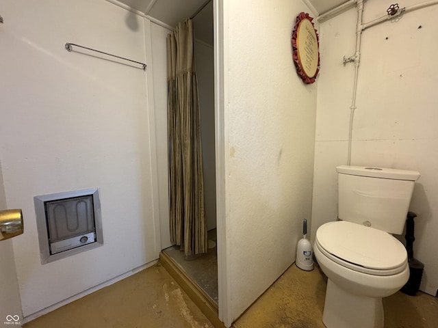 bathroom featuring toilet, concrete flooring, and a shower with curtain