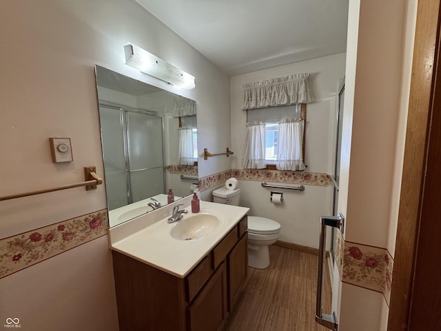 full bathroom with wood finished floors, toilet, a stall shower, and vanity