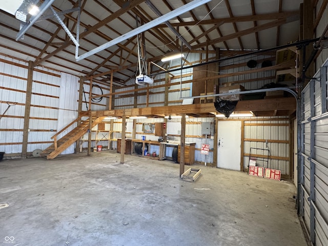 garage featuring electric panel, a garage door opener, and metal wall