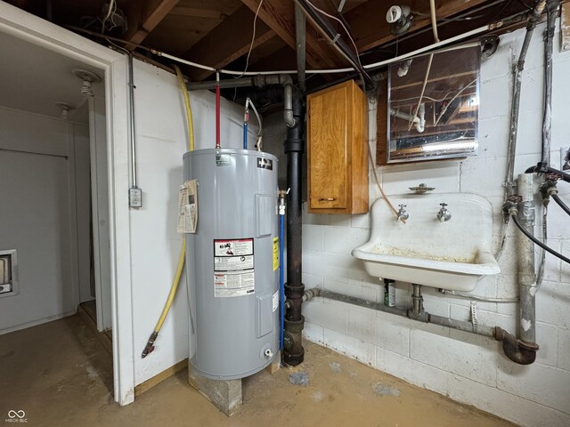 utility room with electric water heater and a sink