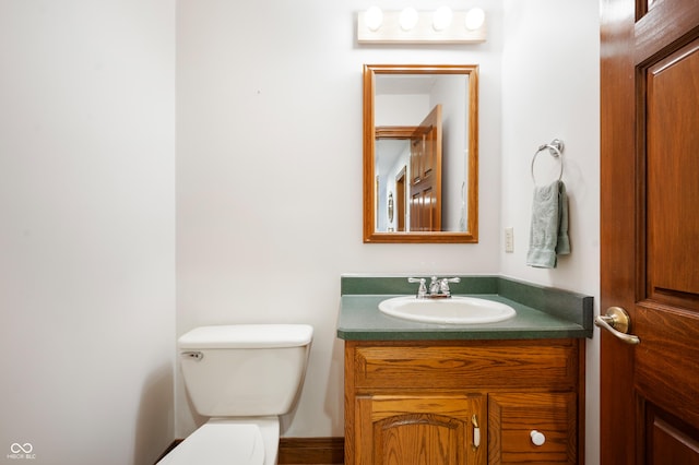 half bath featuring vanity and toilet