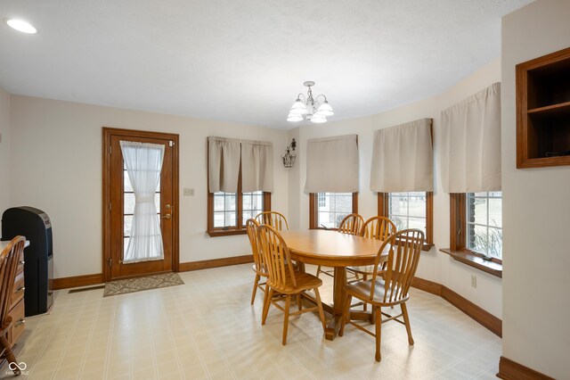 dining room featuring an inviting chandelier and baseboards