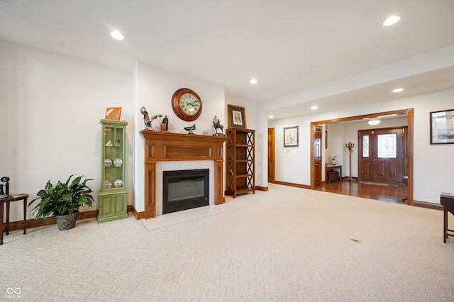 carpeted living area with recessed lighting, baseboards, and a tile fireplace