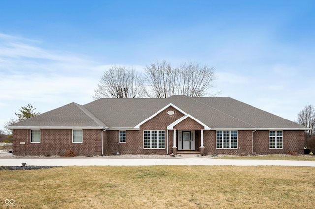 ranch-style house featuring brick siding, a front lawn, and a shingled roof