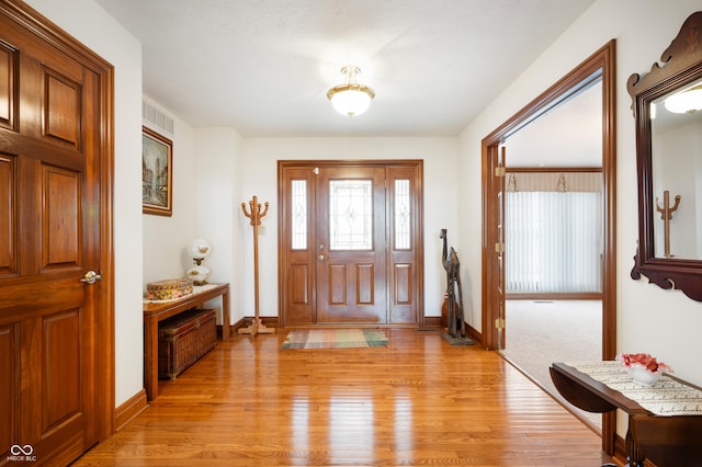 foyer featuring visible vents, baseboards, and light wood-style floors