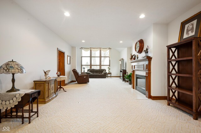 living area with recessed lighting, baseboards, a fireplace with flush hearth, and light colored carpet