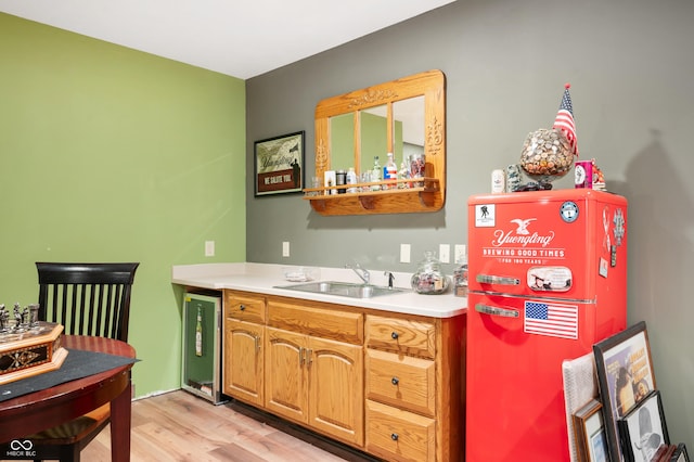 kitchen featuring light wood-style flooring, a sink, light countertops, wine cooler, and white fridge with ice dispenser