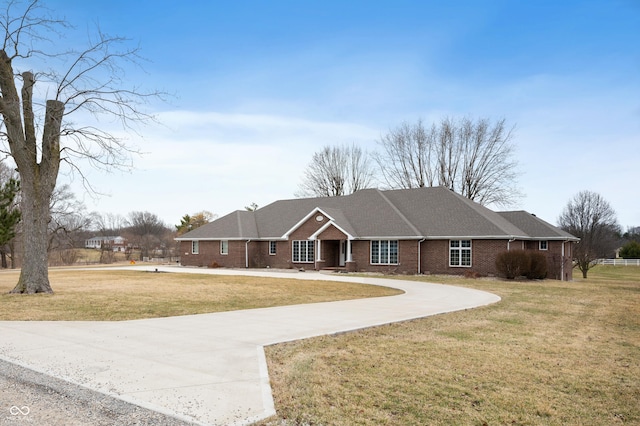 single story home with brick siding, concrete driveway, and a front lawn