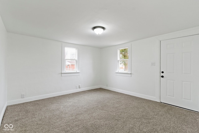 empty room with carpet flooring, a healthy amount of sunlight, and baseboards