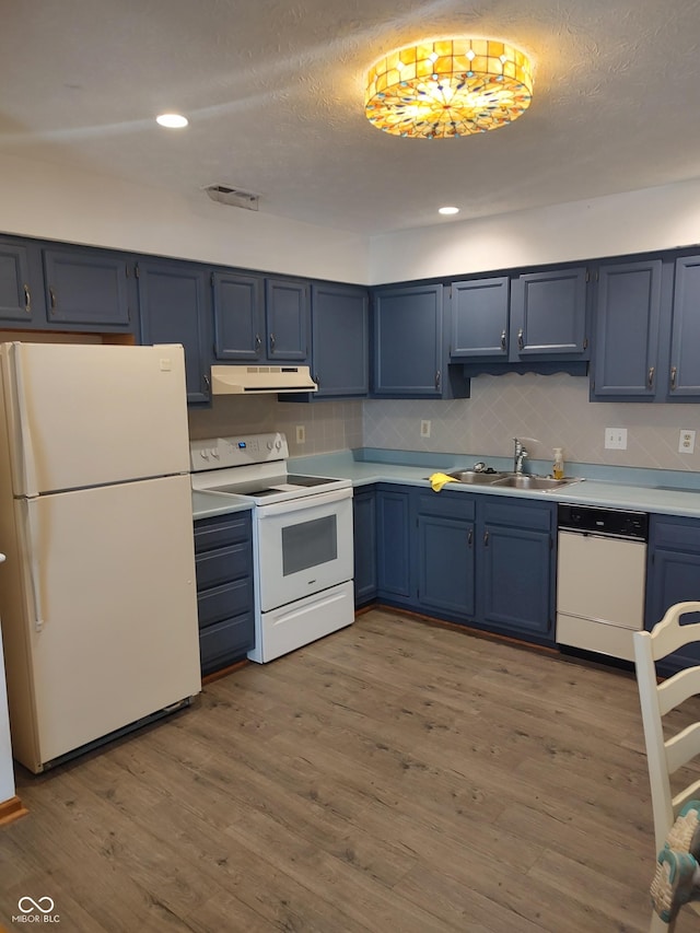 kitchen with a sink, blue cabinetry, wood finished floors, white appliances, and extractor fan