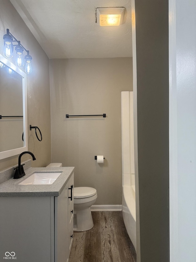 full bath with vanity, wood finished floors, walk in shower, toilet, and a washtub