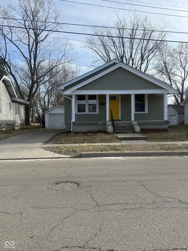 bungalow featuring an outbuilding, a garage, and driveway