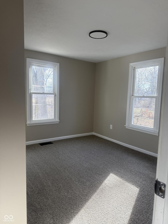 unfurnished room featuring visible vents, baseboards, and carpet