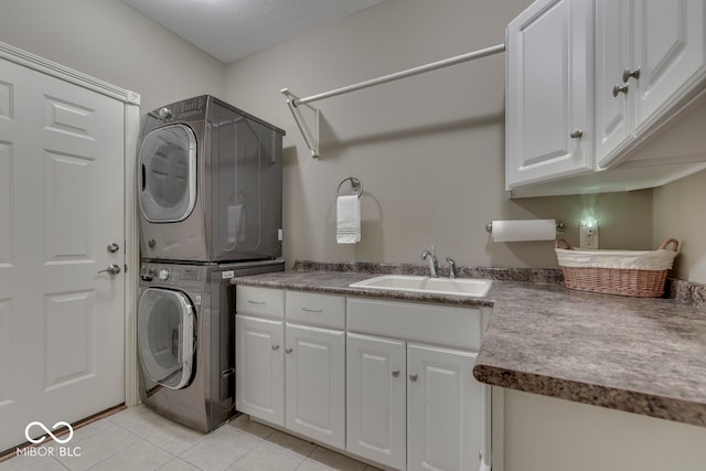 clothes washing area featuring a sink, cabinet space, light tile patterned flooring, and stacked washer / dryer