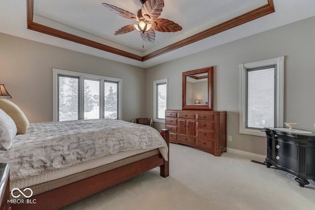 bedroom featuring light colored carpet, crown molding, and a tray ceiling