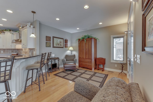 living area with recessed lighting, visible vents, baseboards, and light wood-style floors