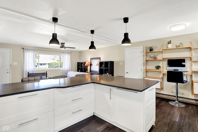 kitchen with dark wood-type flooring, dark countertops, and white cabinets