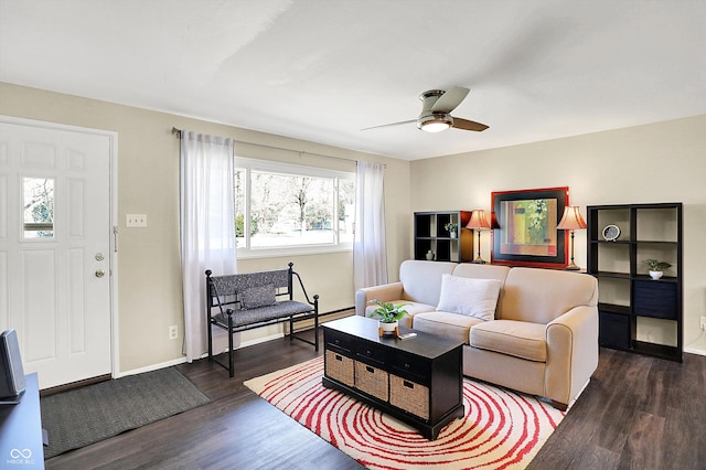 living area with a ceiling fan, baseboards, and wood finished floors