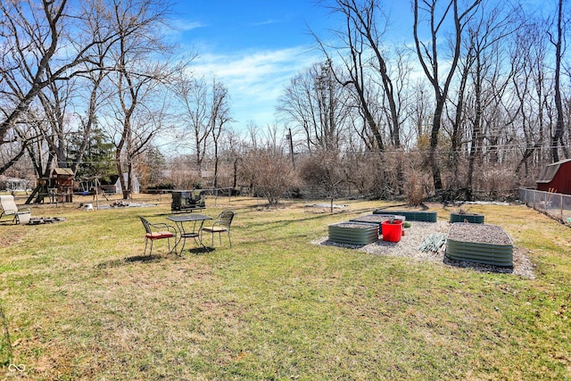 view of yard with a garden, a playground, and fence