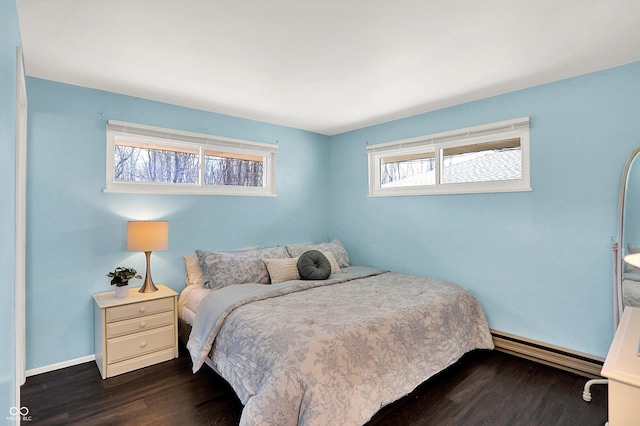 bedroom featuring baseboards, baseboard heating, and dark wood-style flooring