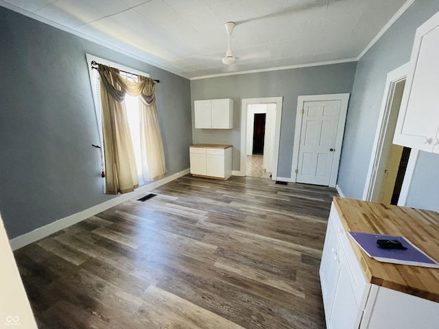 unfurnished bedroom featuring dark wood finished floors, baseboards, and visible vents