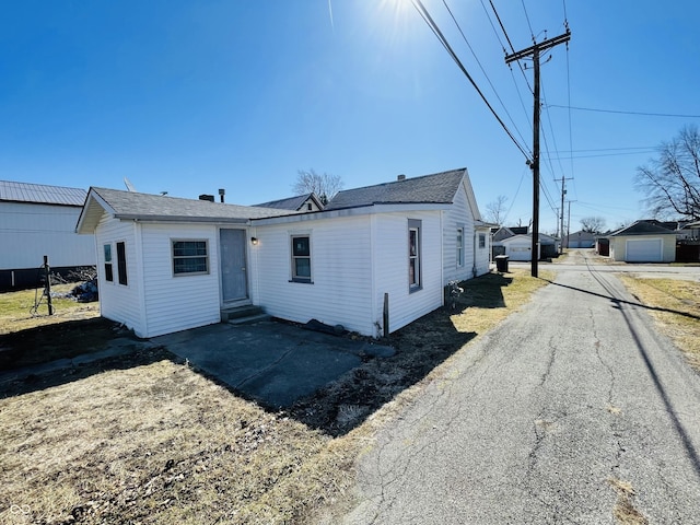 view of front of house with entry steps, aphalt driveway, and a detached garage