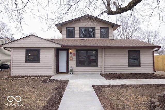 view of front of house with a shingled roof and fence