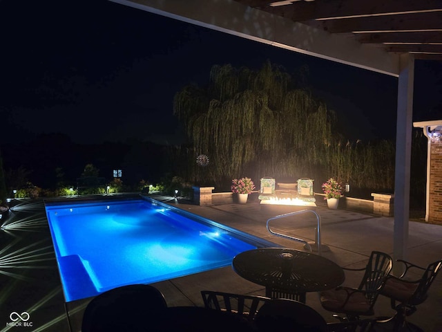 pool at twilight featuring a patio area and outdoor dining space