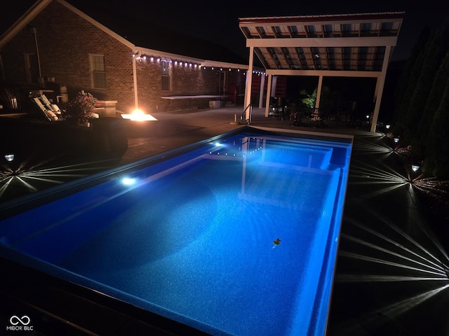 pool at night with a patio area