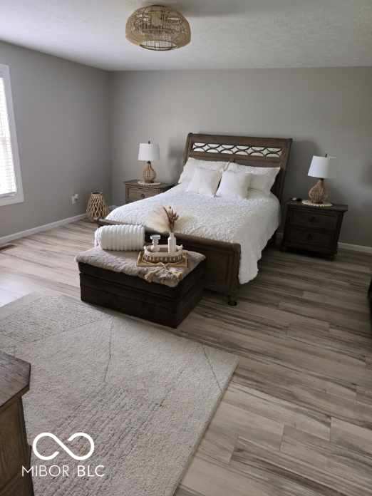 bedroom with baseboards and wood finished floors