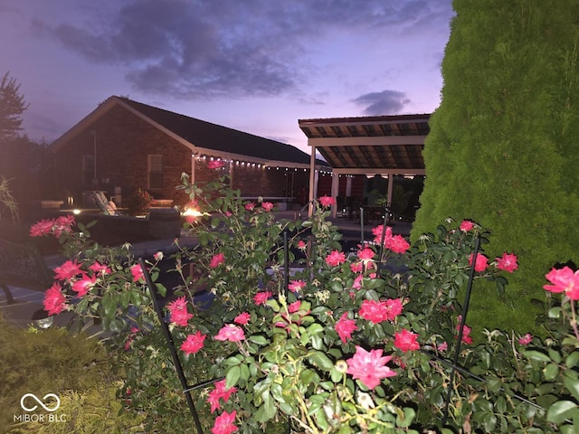 yard at dusk featuring a patio area and a pergola